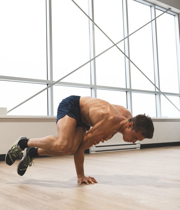 Man performing a controlled strength exercise in a modern, minimalist gym.